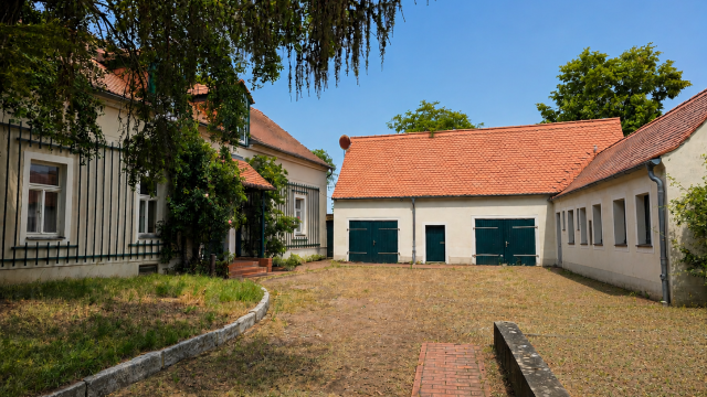 Innenhof mit historischen Gebäuden und roten Ziegeldächern.
